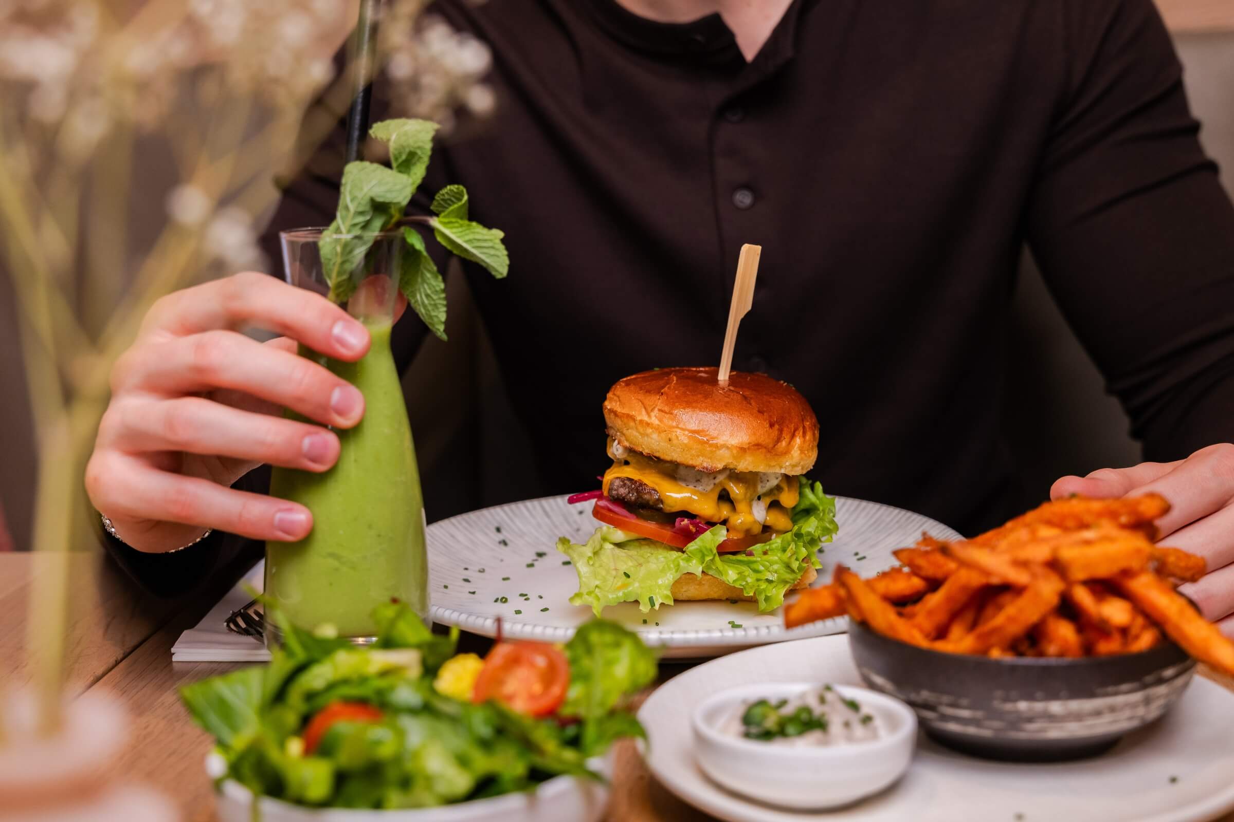 Cheeseburger mit Pommes und grünem Smoothie